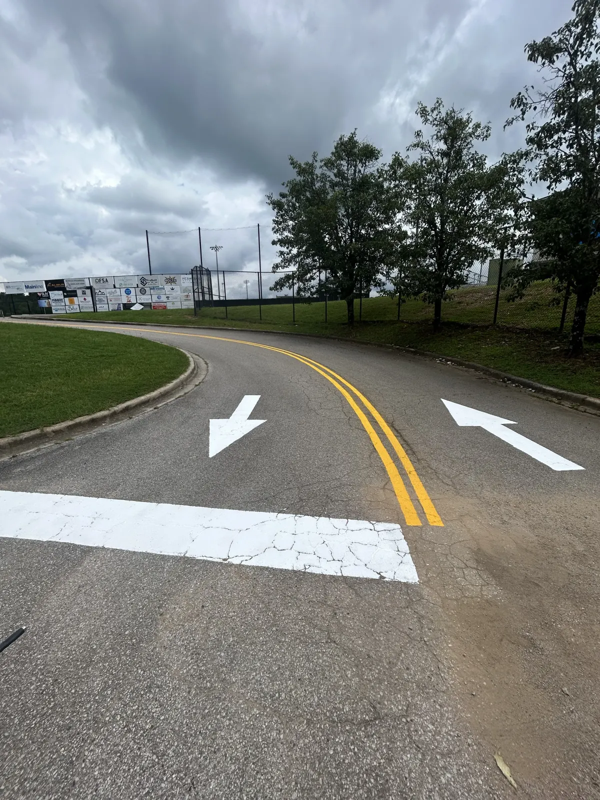 Fresh double yellow centerline, stop bar, and directional arrows painted by BAR Striping
